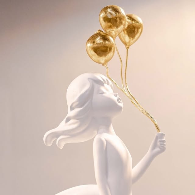 Escultura de porcelana branca de menina com balões dourados