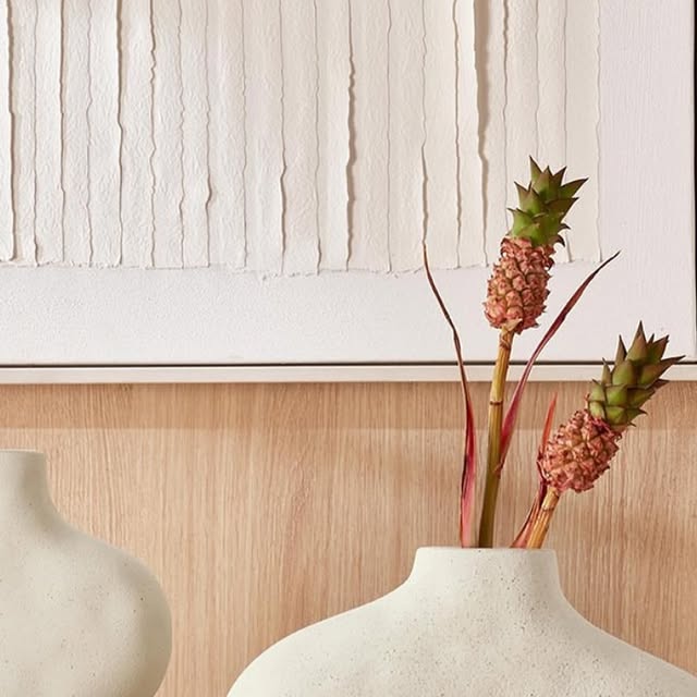 Vaso branco de cerâmica com arranjo de flores secas